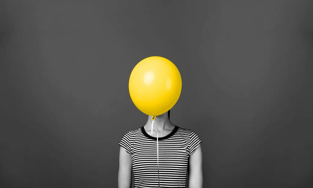 Woman With A Balloon In Front Of Her Face