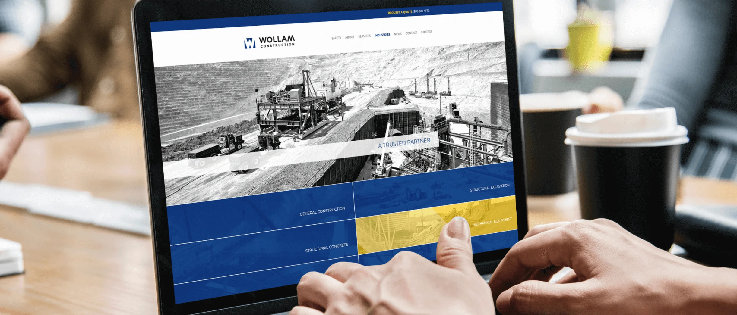 Person Viewing Wollam Construction Website On Laptop