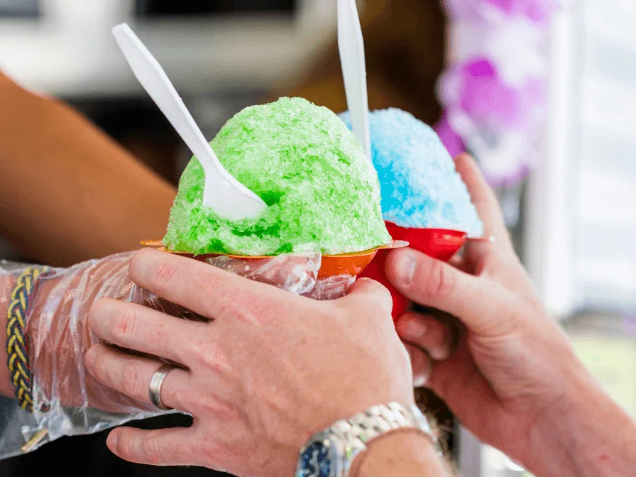 Vendor Handing Out Green And Blue Shaved Ice