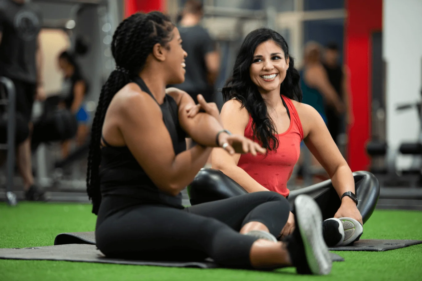 Two Women Sitting Down And Stretching