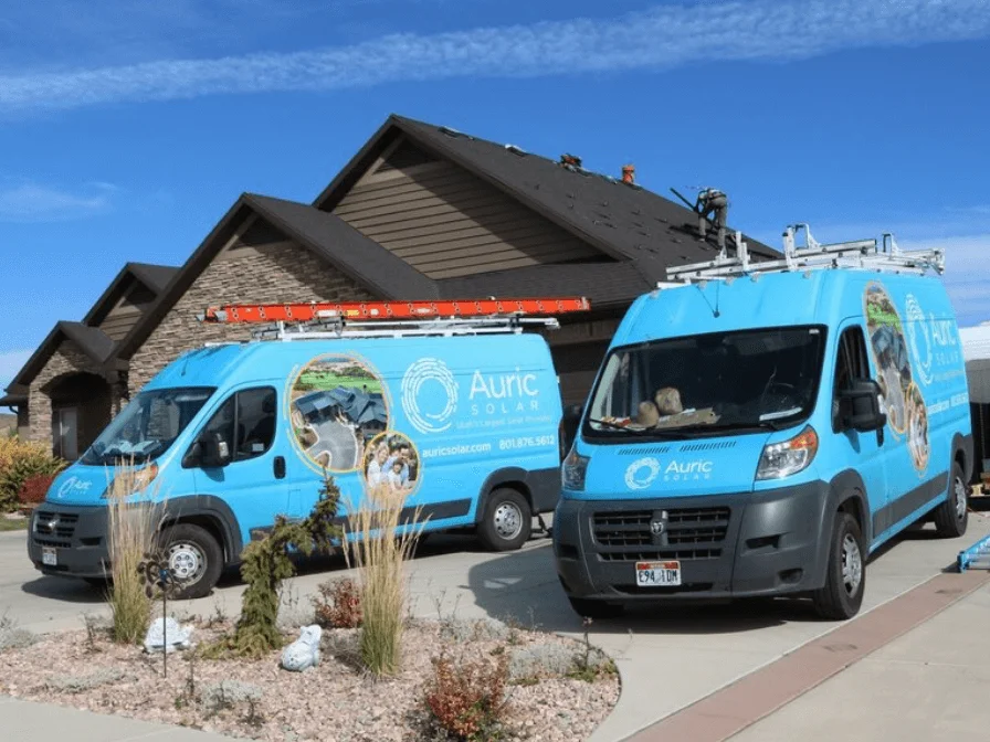 Two Auric Solar Company Vans Parked In A Client's Driveway