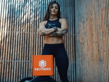 Physically Fit Woman Standing Behind FitBoxx Product