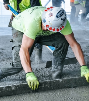 Men in uniform and hardhats working with concrete